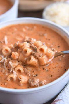 a white bowl filled with macaroni and cheese soup on top of a table