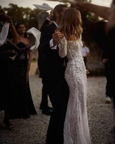 a woman in a white dress standing next to a man