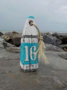 a blue and white buoy sitting on top of a rock