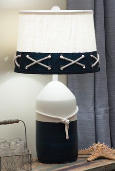 a lamp that is sitting on top of a table next to a glass container and starfish