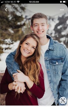 a man and woman hugging each other in the snow