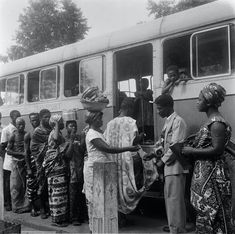 black and white photograph of people boarding a bus