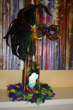 a mardi gras mask in a bottle with feathers