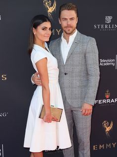 a man and woman standing next to each other on the red carpet at an event