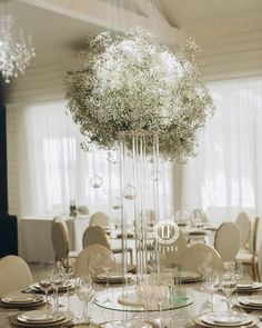 the centerpiece is surrounded by glass vases with baby's breath flowers