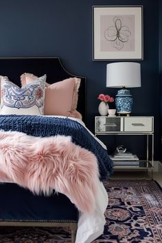 a bedroom with blue walls and pink fur on the bed