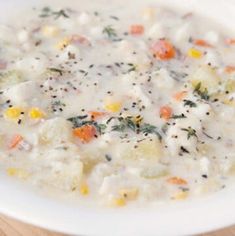 a white bowl filled with soup on top of a wooden table