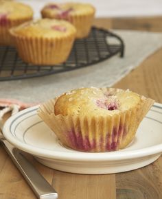 a muffin sitting on top of a white plate next to a fork and knife