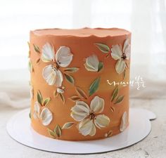 a close up of a cake on a plate with flowers painted on the frosting