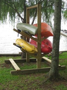 several canoes are stacked up on a wooden stand