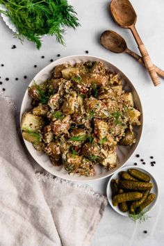 a white bowl filled with food next to two wooden spoons and some green beans