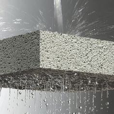 an image of water pouring from a faucet in the air and onto a block of concrete