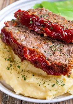 meatloaf and mashed potatoes on a white plate with garnishes