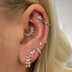 a woman's ear with three different types of piercings