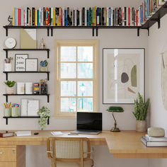 a home office with bookshelves, desk and computer on the wall above it