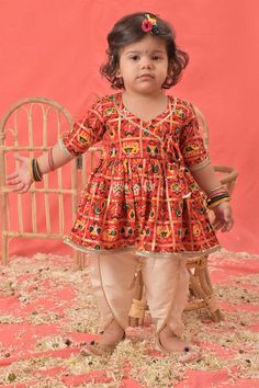 VASTRAMAY SISHU Girls Red Angrakha Style Patola Print Kurta Dhoti Set Dress your little one in vibrant style with this charming kurta dhoti set. The red angrakha kurta features a beautiful patola print, while the comfortable dhoti completes the look. Perfect for festive occasions or special outings. Features: Red angrakha style kurta with patola print V-neck and full sleeves Knee-length kurta Cream dhoti with golden border Specifications: Sleeve Length: Full Sleeves Top Shape: Anarkali Top Type: Kurta Bottom Type: Dhoti Material & Care: Rayon. Dry clean preferably or cold light wash. Legal Disclaimer: The product is guaranteed to be 100% genuine. Product images are for illustrative purposes only. Images/packaging/ labels may vary from time to time due to changes made by the manufacturer's Angrakha Style Kurta, Full Sleeves Top, Anarkali Tops, Patola Print, Angrakha Style, Full Sleeve Top, Golden Border, Vibrant Style, Girls Red