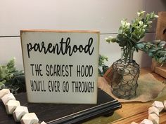 a sign that says parenthood the secret hood you'll ever go through