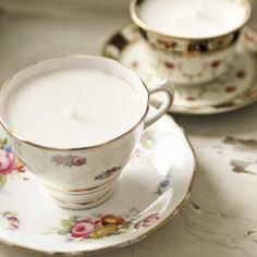 a tea cup and saucer with a lit candle on it