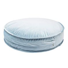 a round blue pillow sitting on top of a white floor cushion in front of a white background