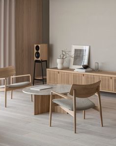 a living room filled with furniture next to a wooden table and speakers on top of it