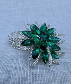 a green flower brooch sitting on top of a table