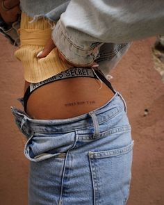 the back of a woman's stomach with her arm wrapped around an object that reads,