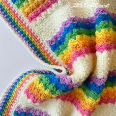 a crocheted blanket with a pair of scissors in it and the end of the afghan