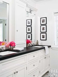 a bathroom with two sinks and pictures on the wall next to each other in black and white