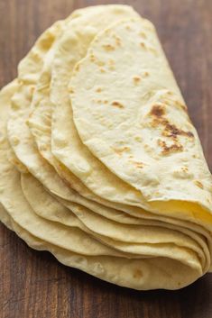 a stack of tortillas sitting on top of a wooden table