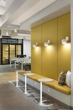 an office with yellow walls and white benches