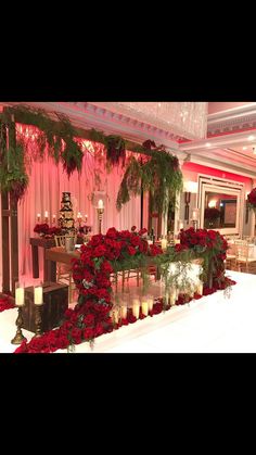 a long table with candles and flowers on it in a room decorated for christmas or new year's eve