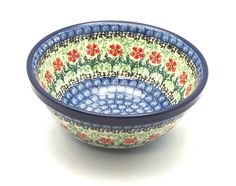 a blue and green bowl with red flowers on it