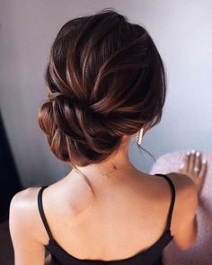 a woman with her hair in a low bun