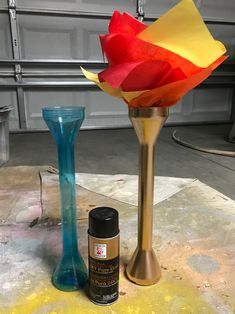 two vases and a spray bottle sitting on a table