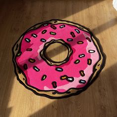 a pink donut rug sitting on top of a wooden floor