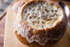 a bowl of soup sitting on top of a wooden cutting board