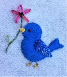 a blue bird with a flower on it's back