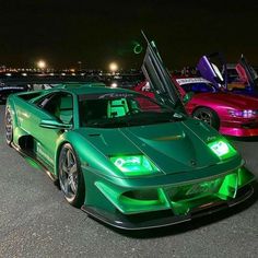 two green sports cars parked next to each other