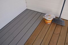 a bucket of ice cream sitting on top of a wooden floor next to a broom