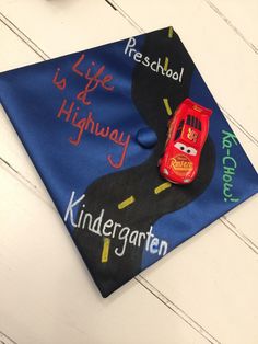 a blue graduation cap with cars on it and the words, life is highway written on it