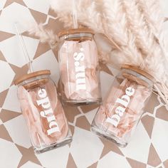 three glass jars with the words bride and groom on them sitting next to a feather