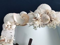 a mirror with seashells and flowers on it