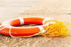 an orange life preserver and rope on the ground