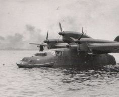 an old airplane floating in the water next to a small plane on top of it