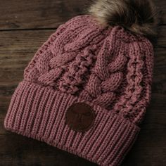 a pink hat with a fur pom