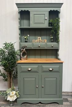 a green hutch sitting next to a potted plant