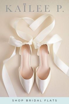 a pair of white shoes tied up to a wall with the words, shop bridal flats