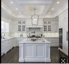 a large kitchen with white cabinets and an island