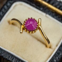 This vintage ruby bypass ring features a round cabochon cut ruby set into 16-prongs. The ring is crafted in 18k yellow gold and is currently a size 6.5. Ruby Set, Bypass Ring, September Birthstone, The Ring, High Quality Jewelry, Druzy Ring, Estate Jewelry, Sapphire Ring, Ruby