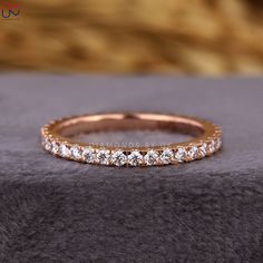 a gold wedding band with five round diamonds on the top and bottom, set in 18k rose gold